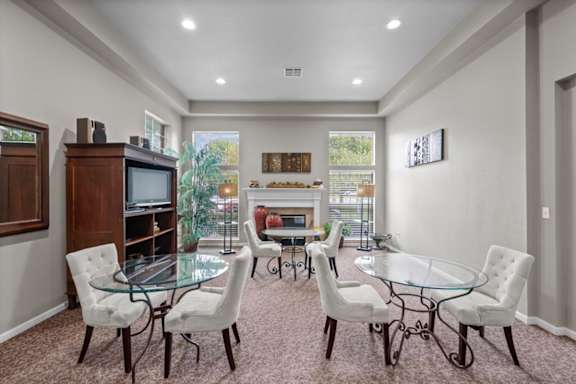 A living room with a glass table and white chairs.at Crowne Chase Apartment Homes, Kansas, 66210