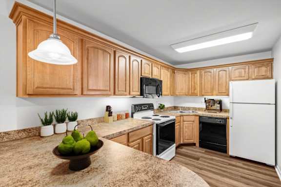 A kitchen with wooden cabinets and a granite countertop. at Malvern Hill Apartment Homes, 66103