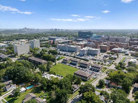 A cityscape with buildings and greenery under a clear sky. at Malvern Hill Apartment Homes, 66103, KS