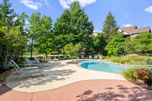 Pool surrounded by trees and seating around it at Stonepost Ranch Apartments, Kansas