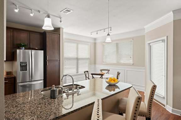 A kitchen with a granite countertop and a refrigerator.