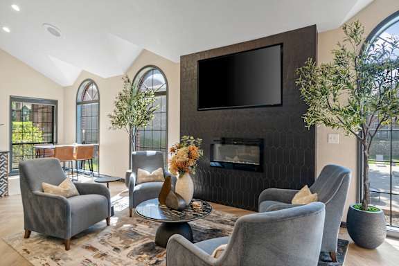 A living room with grey chairs and a black television.