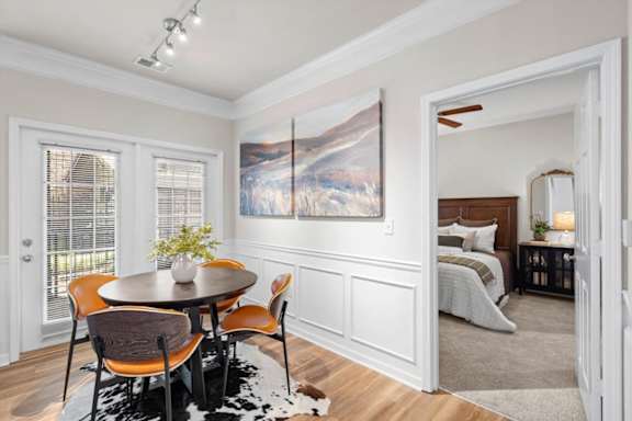 Dining room with wooden table and chairs with bedroom view at Deer Creek Apartment Homes, Overland Park, KS, 66213