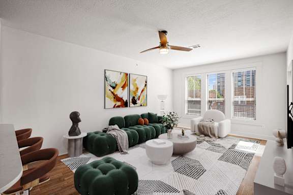 A living room with a green sofa and a white rug.