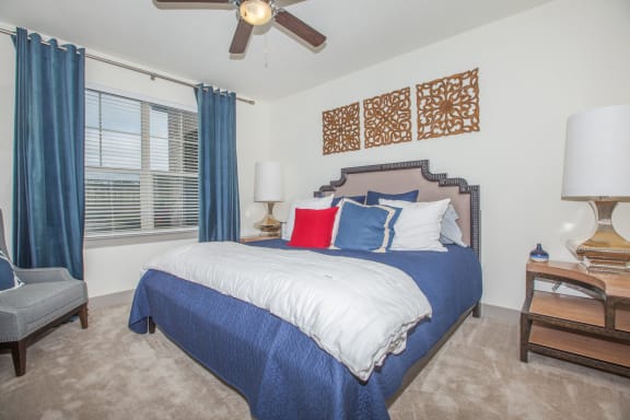 carpeted bedroom with bed and nightstand at Ovation at Lewisville Apartments, Texas , 75067