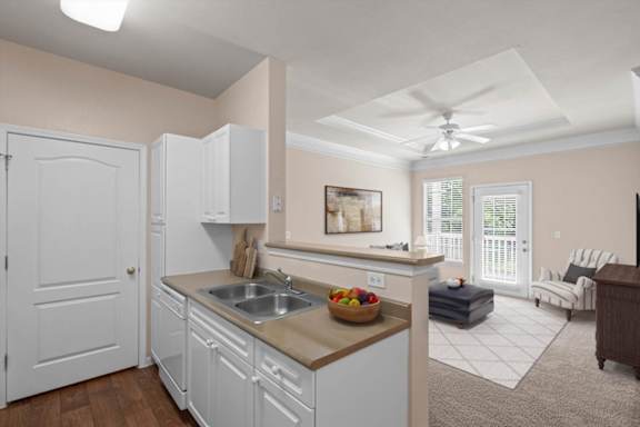 A kitchen with white cabinets and a beige countertop.