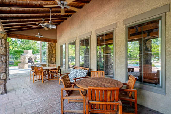 Patio with wooden tables and chairs at Stonepost Ranch Apartments, Kansas, 66221