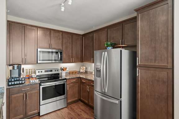 A kitchen with wooden cabinets and stainless steel appliances.