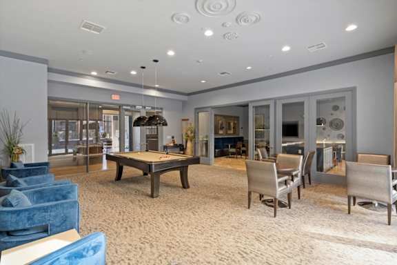 A spacious room with a ping pong table and chairs.