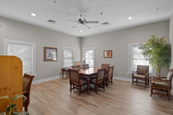 a dining room with a table and chairs and a ceiling fan