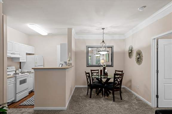 A kitchen with a dining table and chairs.