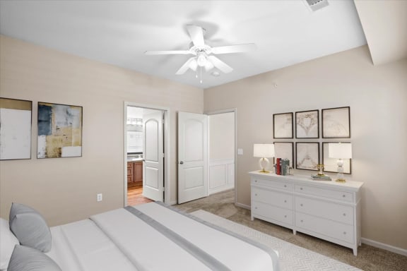 a bedroom with a white bed and a ceiling fan at Stonepost Ranch Apartment Homes, Overland Park, 66221