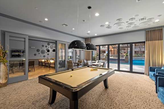 A billiard table is in the middle of a room with a pool table and a bar.