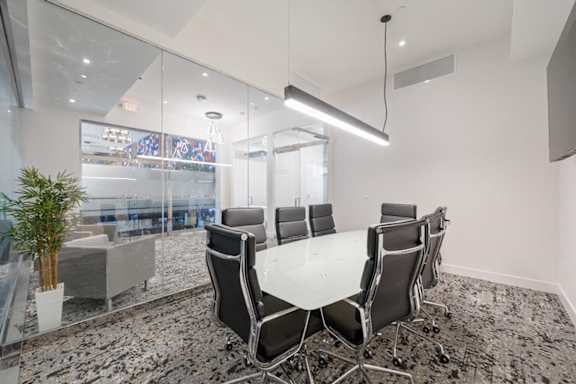A conference room with a glass table and chairs.