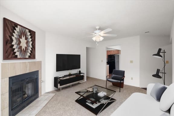 a living room with a fireplace and a tv at Deerfield Apartments, Kansas