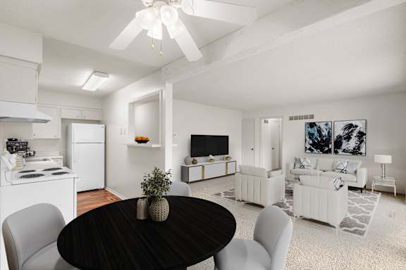 A living & dining area with an open layout, ceiling fan, and a combination of carpet and hardwood floors.