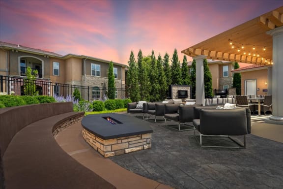 a patio with couches and a fire pit