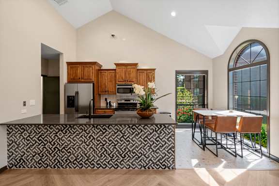 A kitchen with a black and white patterned bar.