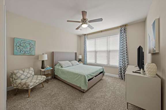 A bedroom with a bed, chair, and television.