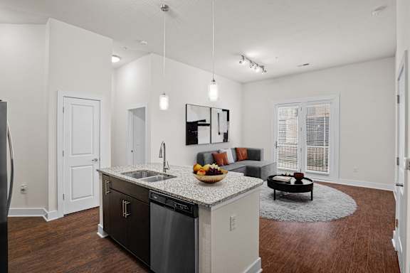 A modern kitchen with dark wood floors and white walls at West 39th Street Apartments, Kansas City, Missouri