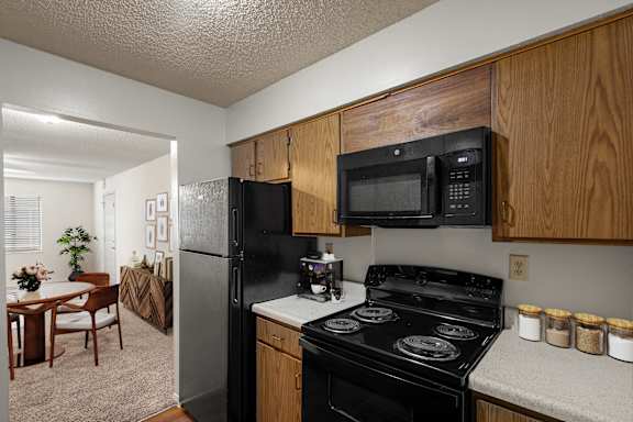 A kitchen with a black refrigerator, microwave and range in an apartment at Bristol Pointe in Olathe, Kansas.