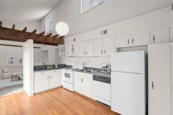 A modern kitchen with white cabinets and appliances.