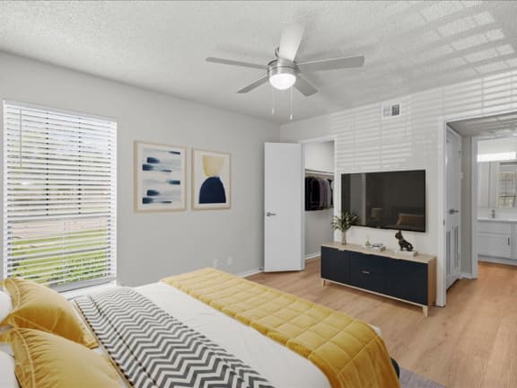 a bedroom with a bed and a ceiling fan