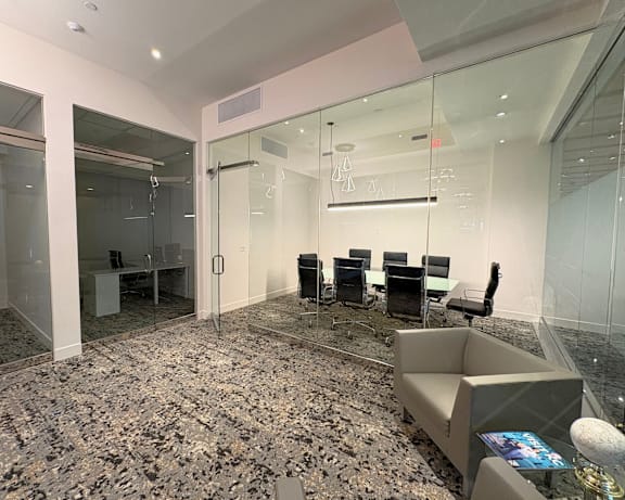 Spacious conference room area at Sky on Main Apartments, featuring a waiting area, two private workspaces, and a dedicated meeting room.