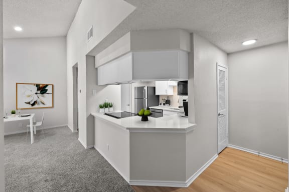 an open kitchen and living room with white walls and white countertops