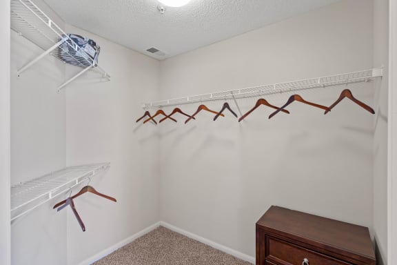 a walk in closet with a dresser and hangers at Claremont, Overland Park, KS, 66210