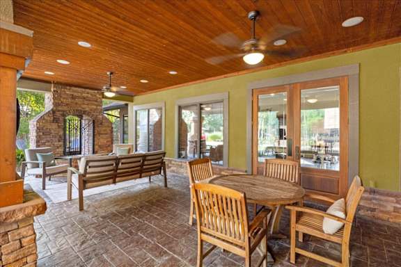 Outdoor patios with tables, chairs and fireplace at Deer Creek Apartment Homes, Kansas