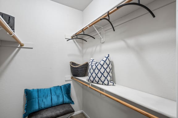 a closet with a shelf and a chair