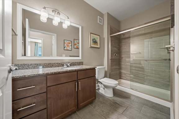 A bathroom with a sink, toilet, and shower.