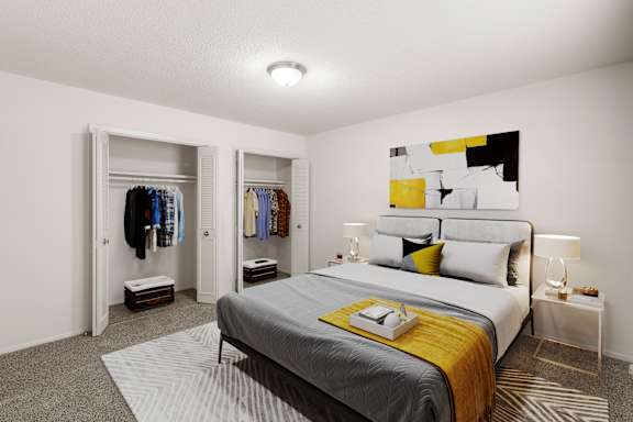 A bedroom with a ceiling light, two spacious closets with french doors, and carpet throughout.