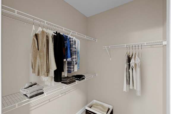 A large walk-in bedroom closet with built-in wire racks.