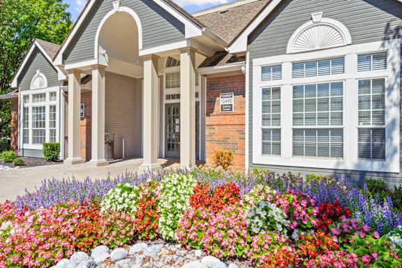 The clubhouse and leasing office with a gorgeous flower bed at Stonebriar Apartments in Overland Park, KS.
