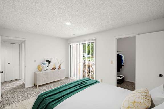 A bedroom with a bed, a couch, and a television.