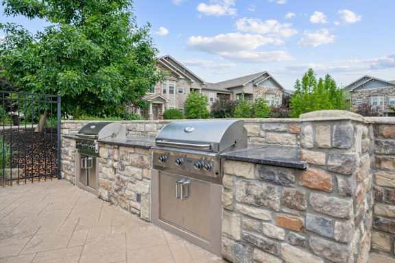 A stone wall with a grill on top. at Stonepost Crossing Apartments, Overland Park, Kansas