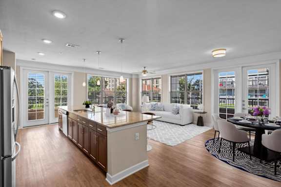 a kitchen with a center island next to a living room with a couch and a table at The Dorset, Kansas City, Missouri