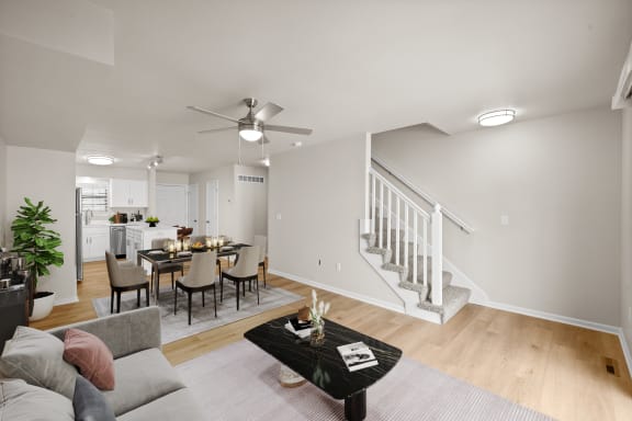 the living room and dining area of a home with a staircase and a dining table