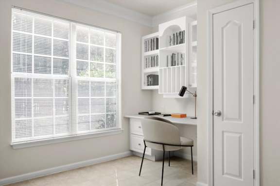 A room with a desk, chair, and bookshelf at Wynnewood Farms Apartments, Overland Park 66209