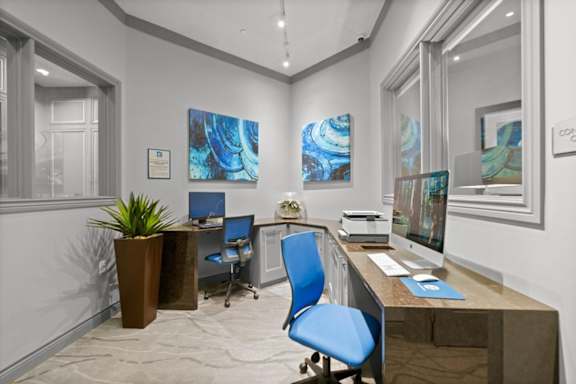 A modern office with blue chairs and artwork on the walls.