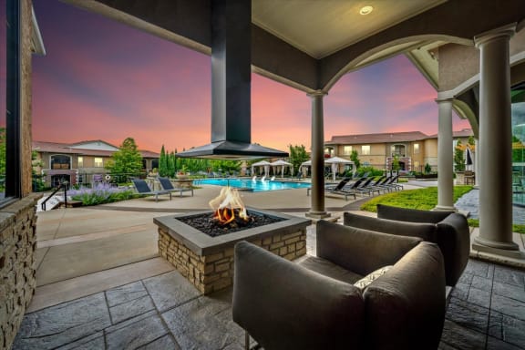 a patio with couches and a fire pit
