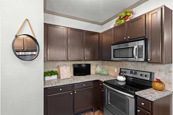 A kitchen with brown cabinets and a black stove top oven.