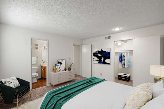 A primary bedroom with a large walk-in closet and an attached bathroom.