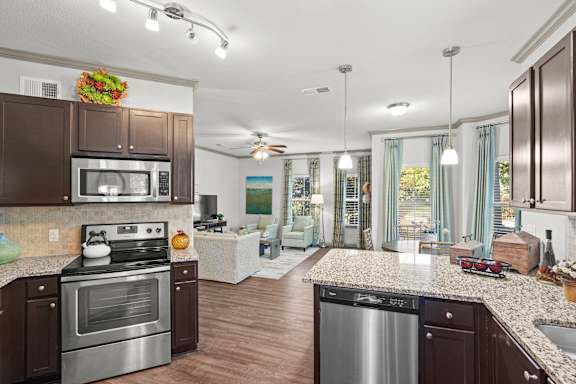 A kitchen with brown cabinets and a stainless steel oven.