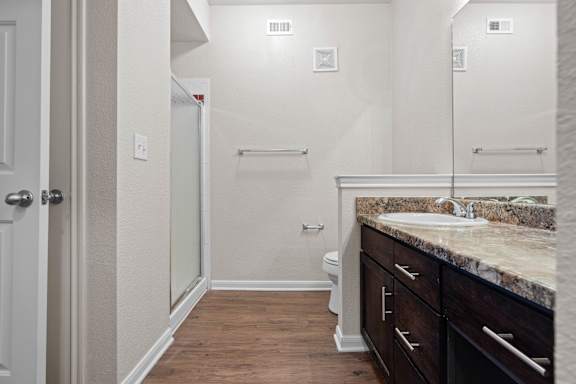 A bathroom with a sink, mirror, and toilet.