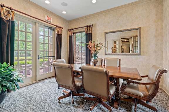 A conference room with a table and chairs and a mirror on the wall.