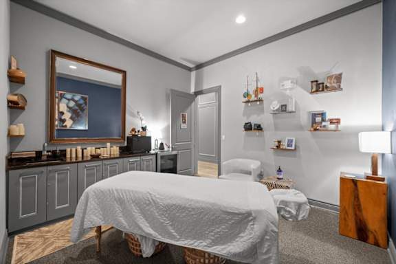 A bedroom with a bed, a nightstand, and a painting on the wall.