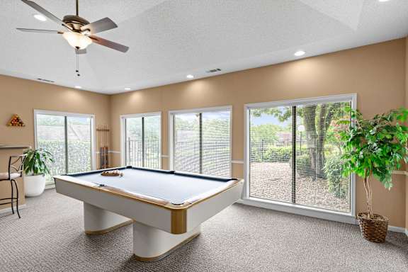 A pool table in a room with a ceiling fan and sliding glass doors. at Coventry Oaks Apartments, Overland Park, KS, 66214